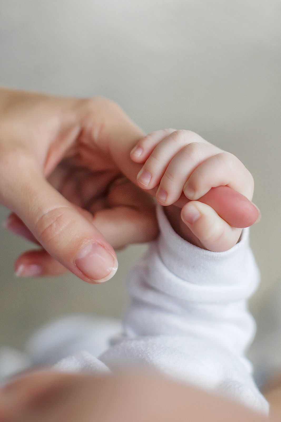baby holding mom's hand
