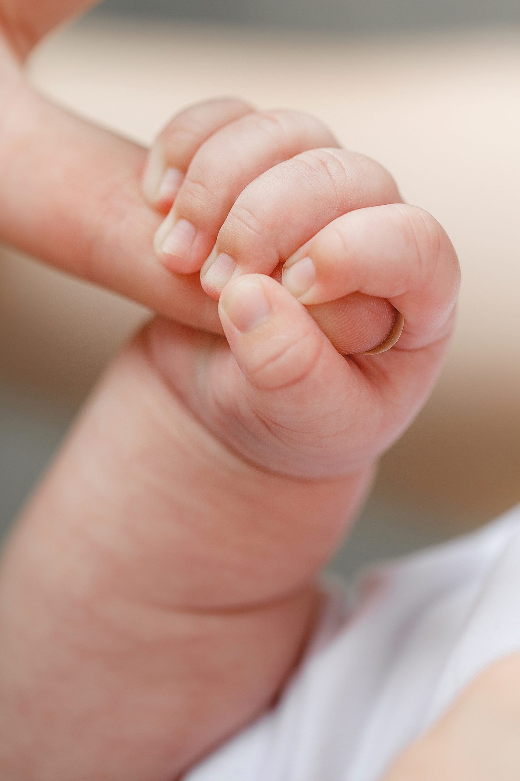 close of baby hand holding mom's hand
